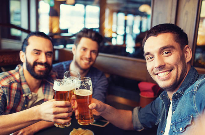 people, leisure, friendship, technology and bachelor party concept - happy male friends taking selfie and drinking beer at bar or pub
