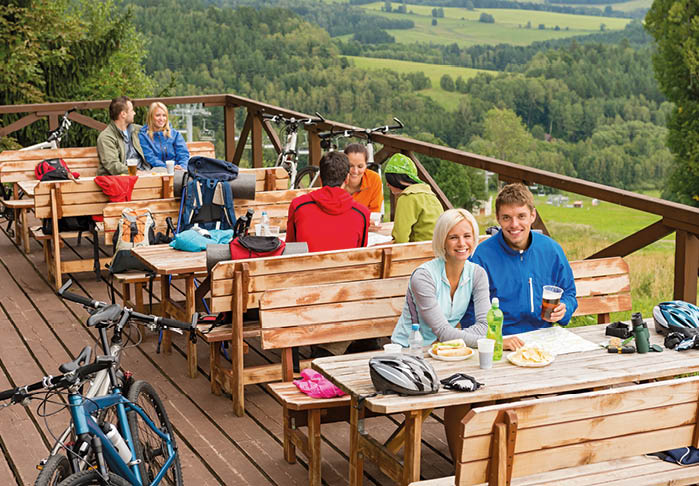 Young people relaxing looking at scenic mountain landscape summer holiday